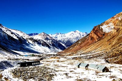 Scenic view of snowcapped mountains against clear blue sky