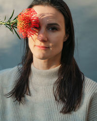 Portrait of young woman with eyes closed standing against wall