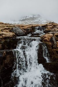 Scenic view of waterfall during foggy weather