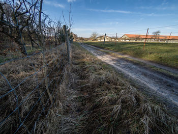 Road amidst field against sky