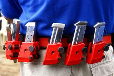 Midsection on man handguns standing outdoors