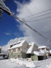 Low angle view of houses against sky during winter