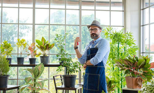 Man holding potted plant at home