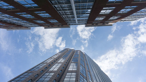 Low angle view of modern building against cloudy sky