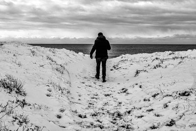 Rear view of woman walking on beach