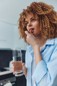 Portrait of young woman drinking glass