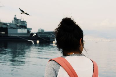 Rear view of woman looking at sea against sky