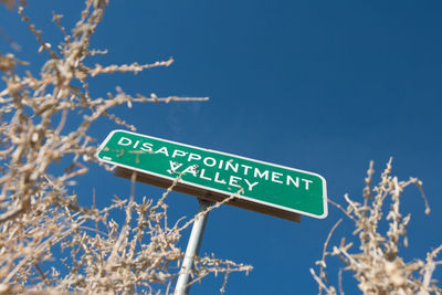 Low angle view of road sign against clear sky