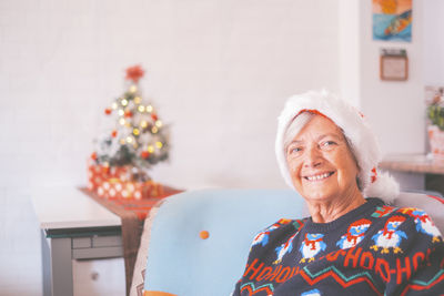 Portrait of smiling senior woman sitting at home