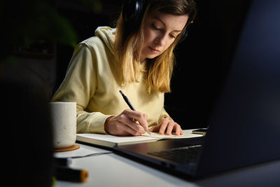 Female designer working in home office at night