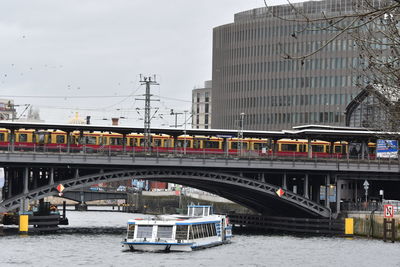 Bridge over river in city against sky