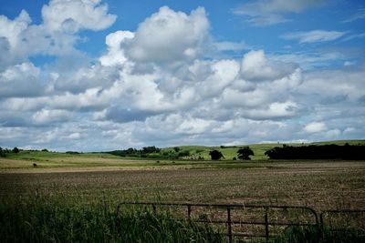 Scenic view of field against cloudy sky