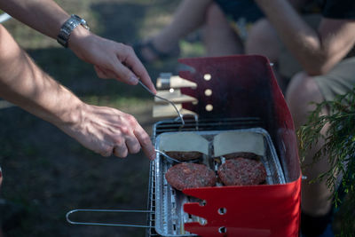 Close-up of hands on barbecue grill