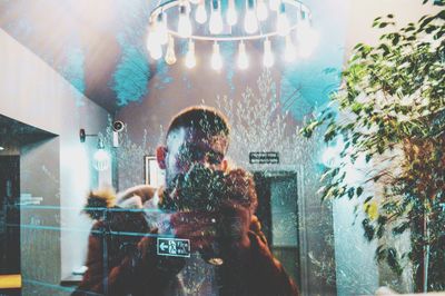 People photographing illuminated glass window