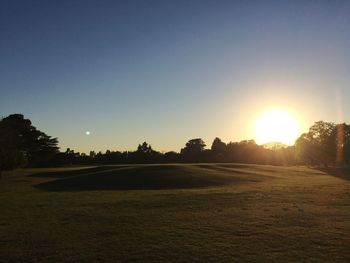 Scenic view of field against clear sky during sunset