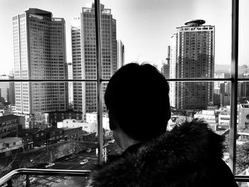 Man looking at cityscape against clear sky