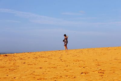 Woman standing on beach against sky