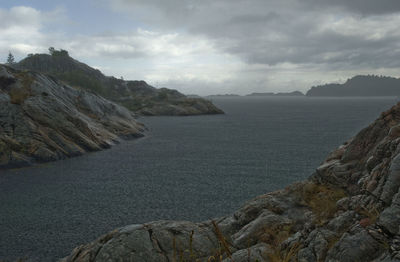 Scenic view of sea and mountains against sky