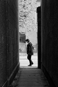 Side view of man standing by building