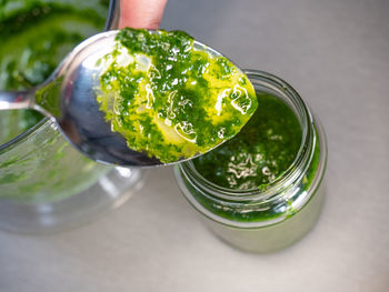 High angle view of hand holding glass on table