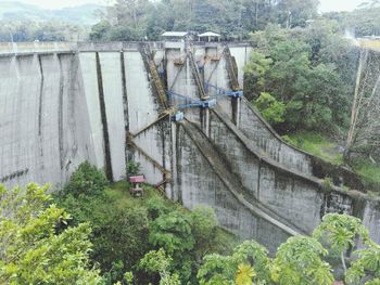 Panoramic view of footbridge in forest against sky