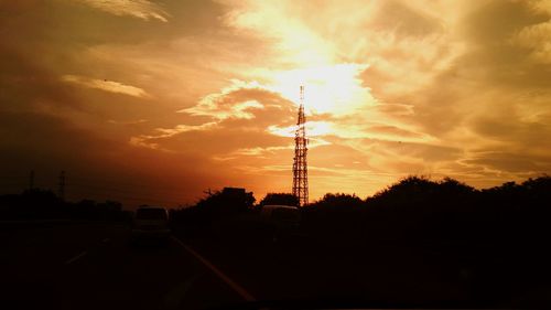 Silhouette of electricity pylon at sunset