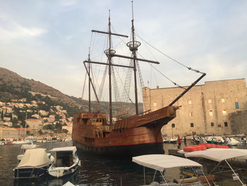 Ship moored at harbor against sky