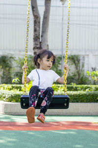 Full length of girl on swing at playground