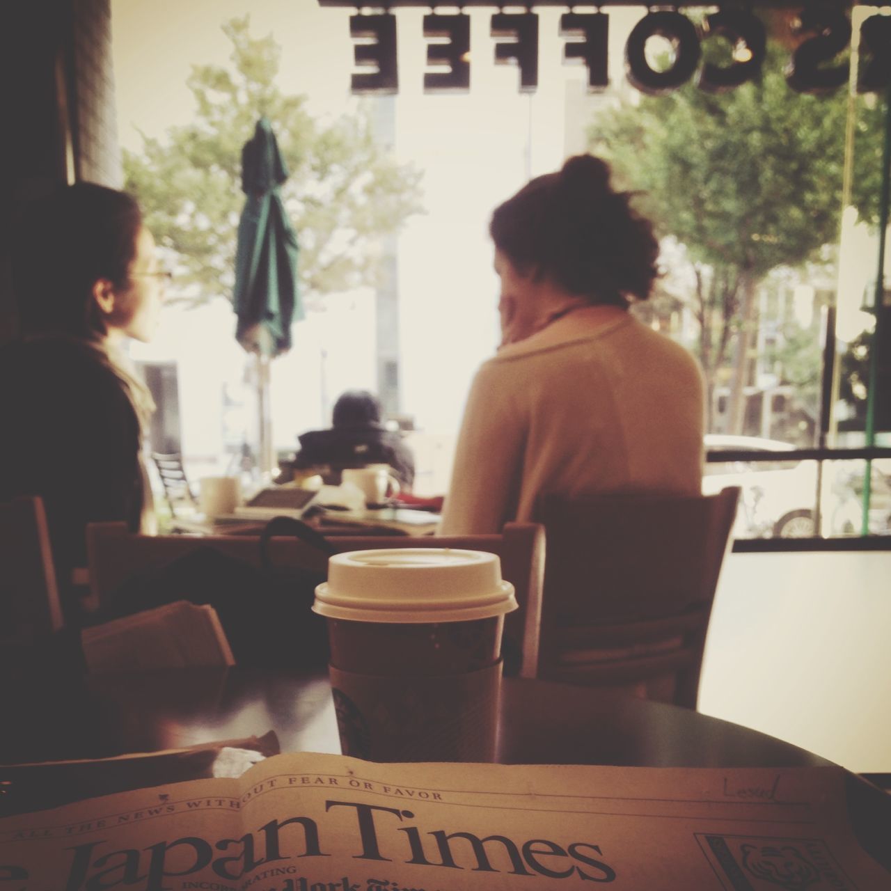 food and drink, lifestyles, focus on foreground, table, sitting, men, indoors, restaurant, drink, leisure activity, rear view, person, incidental people, chair, communication, text, cafe, coffee cup