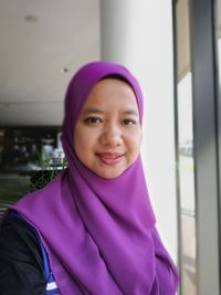 Portrait of smiling mid adult woman wearing hijab at home