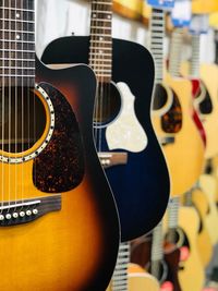 Close-up of guitars hanging in store for sale