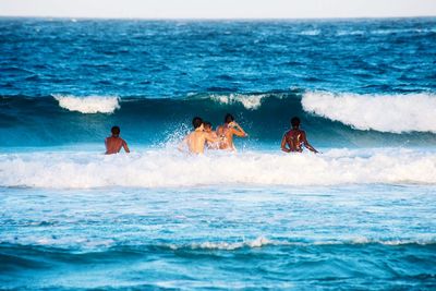People at sea shore against sky