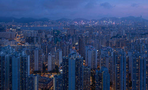 Aerial view of illuminated buildings in city against sky at night