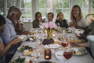 Multi-generation family enjoying dinner on table during party at home