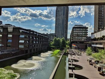 Buildings by swimming pool against sky in city