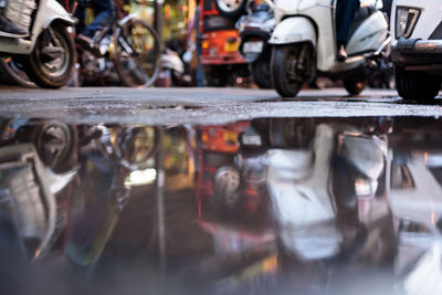 Vehicles reflecting in puddle on street