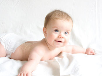 Portrait of cute baby lying on bed