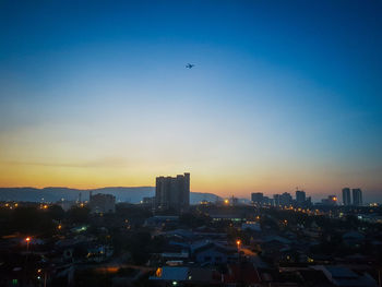 Aerial view of buildings in city against sky during sunset