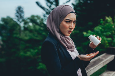 Portrait of young woman holding ice cream cone outdoors