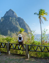 Rear view of woman walking on bridge against sky