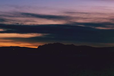 Scenic view of silhouette mountains against dramatic sky