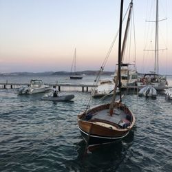 Boats in sea at sunset