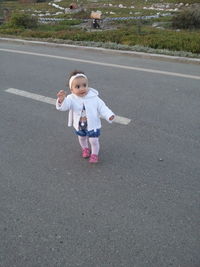 Full length of cute girl standing on road