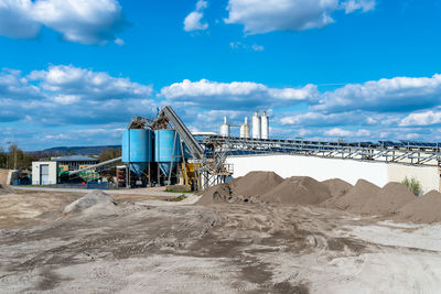 Heaps of gravel and crushed on blue sky at an industrial cement plant.