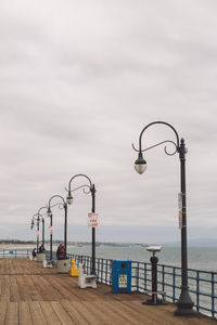 Street light by sea against sky