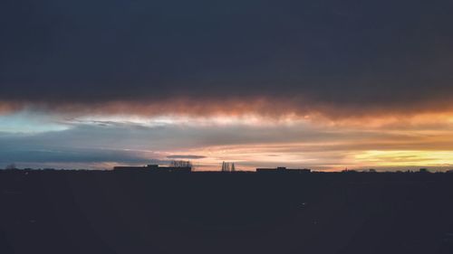 Silhouette cityscape against sky during sunset