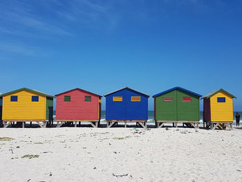 Multi colored umbrellas on beach against clear blue sky