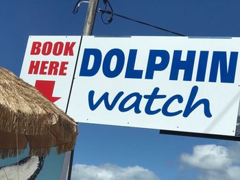 Low angle view of information sign against blue sky