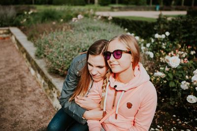 Portrait of two friends sitting in garden