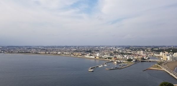 High angle view of townscape by sea against sky